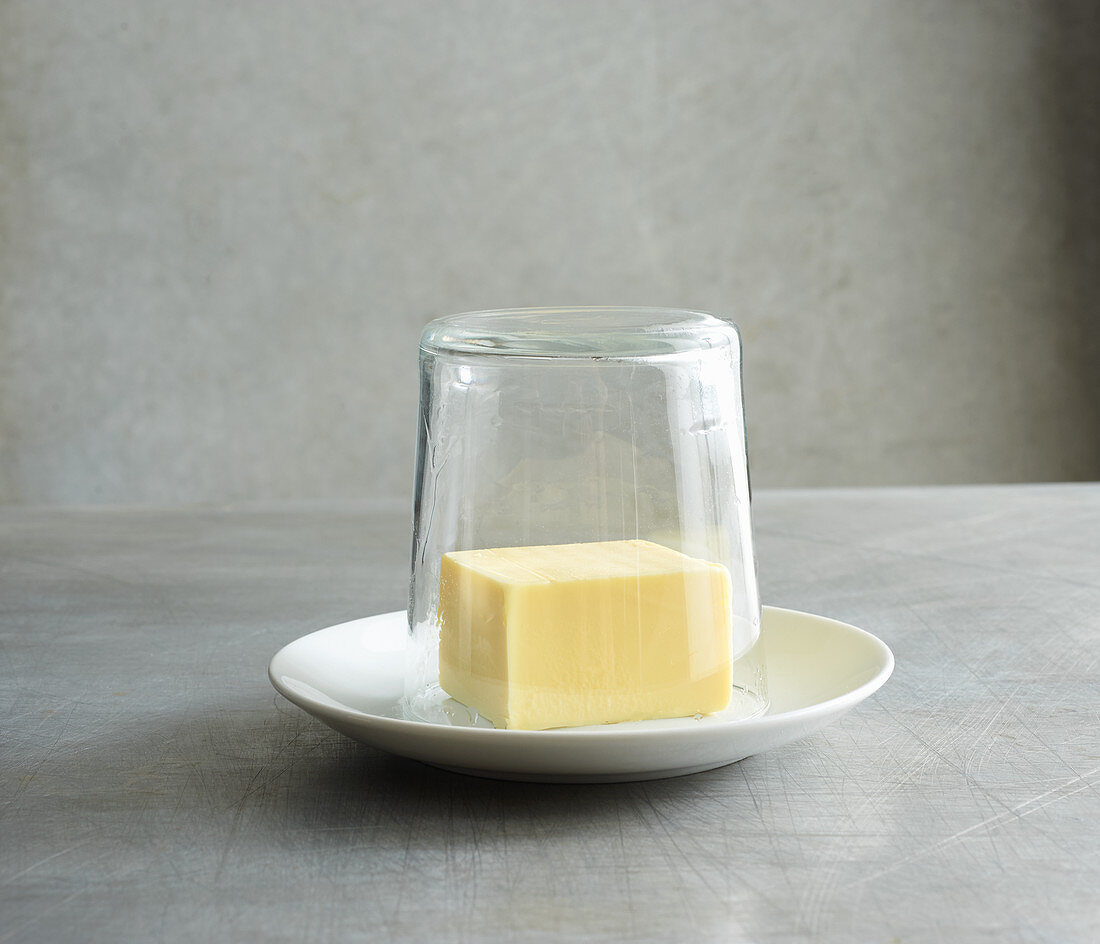 Butter being covered with a hot glass to soften it