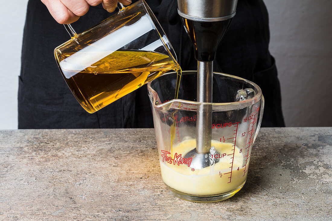 Oil being slowly mixed into a mayonnaise mixture