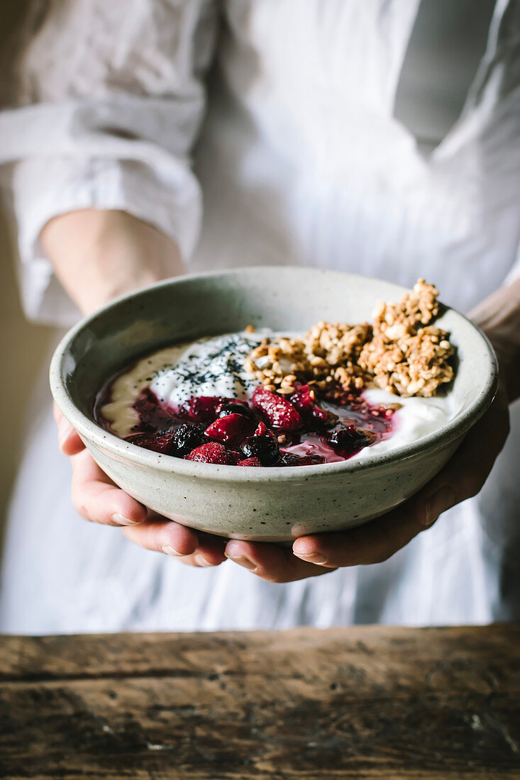 Faceless person holding delicious breakfast bowl with quinoa, rice and groats