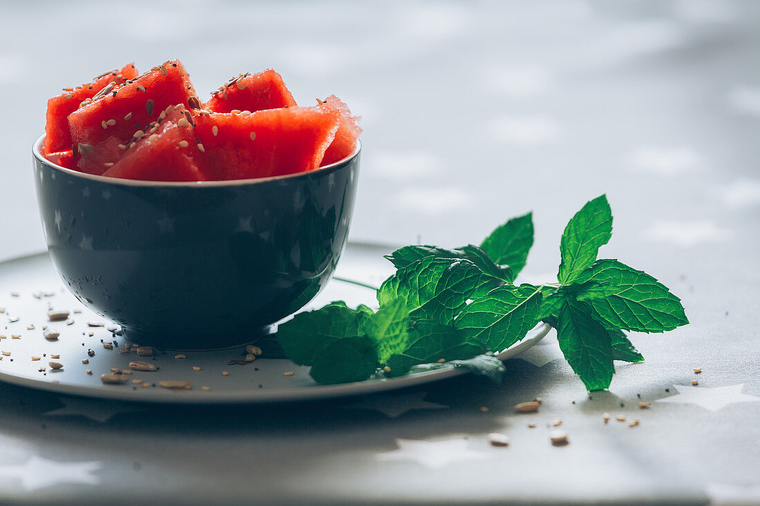 Watermelon in bowl garnished with mint leaves