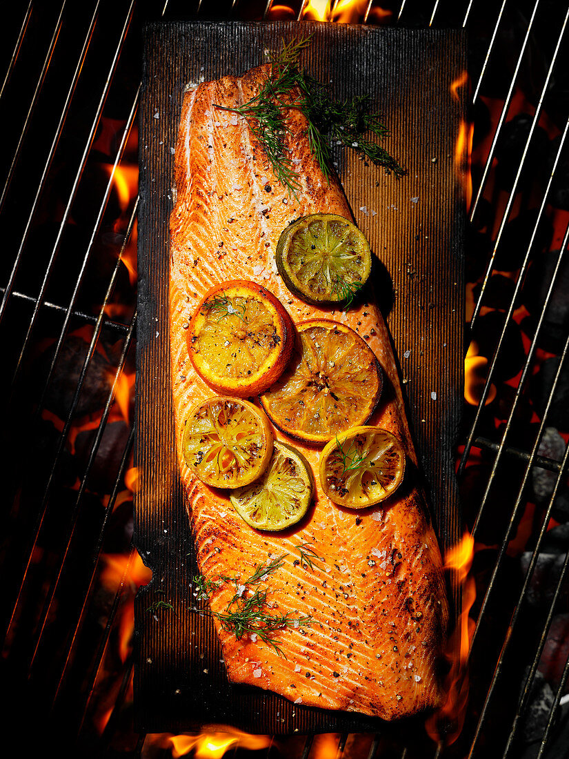 Cedar-planked salmon with citrus and herbs over flames and coals