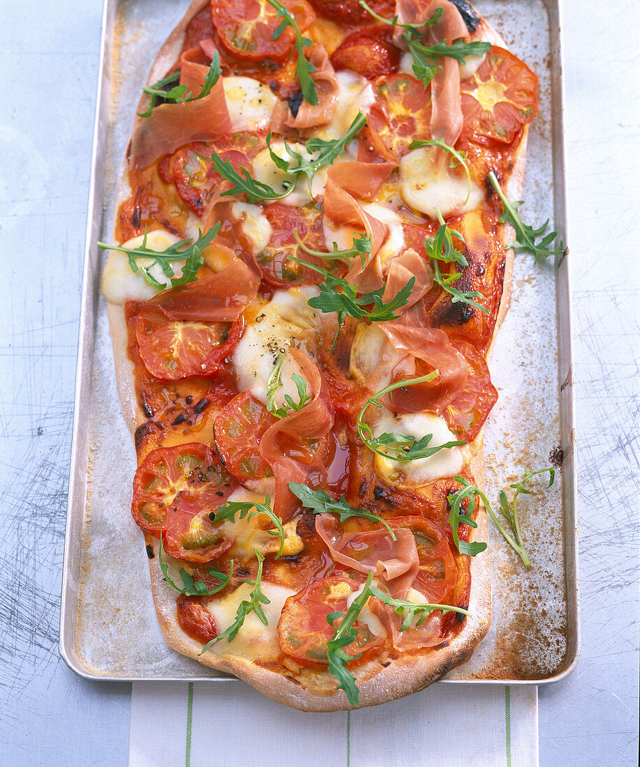 Pizza with tomatoes, rocket and Parma ham