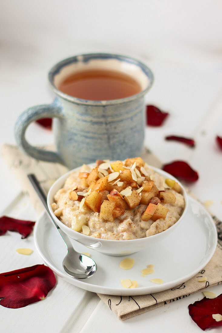 Apfel-Zimt Porridge mit Mandelblättchen und Tasse Tee