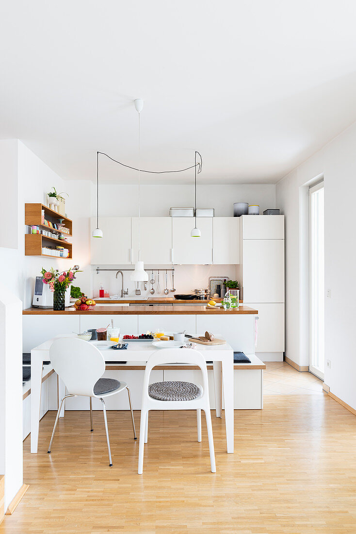 Dining area with DIY corner bench made from kitchen wall cabinets and worksurface