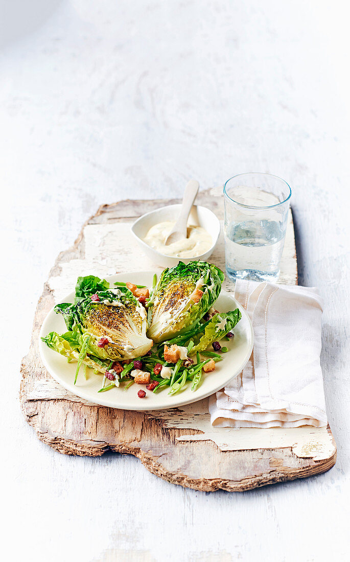 Grilled romaine lettuce hearts with bacon and cream dressing