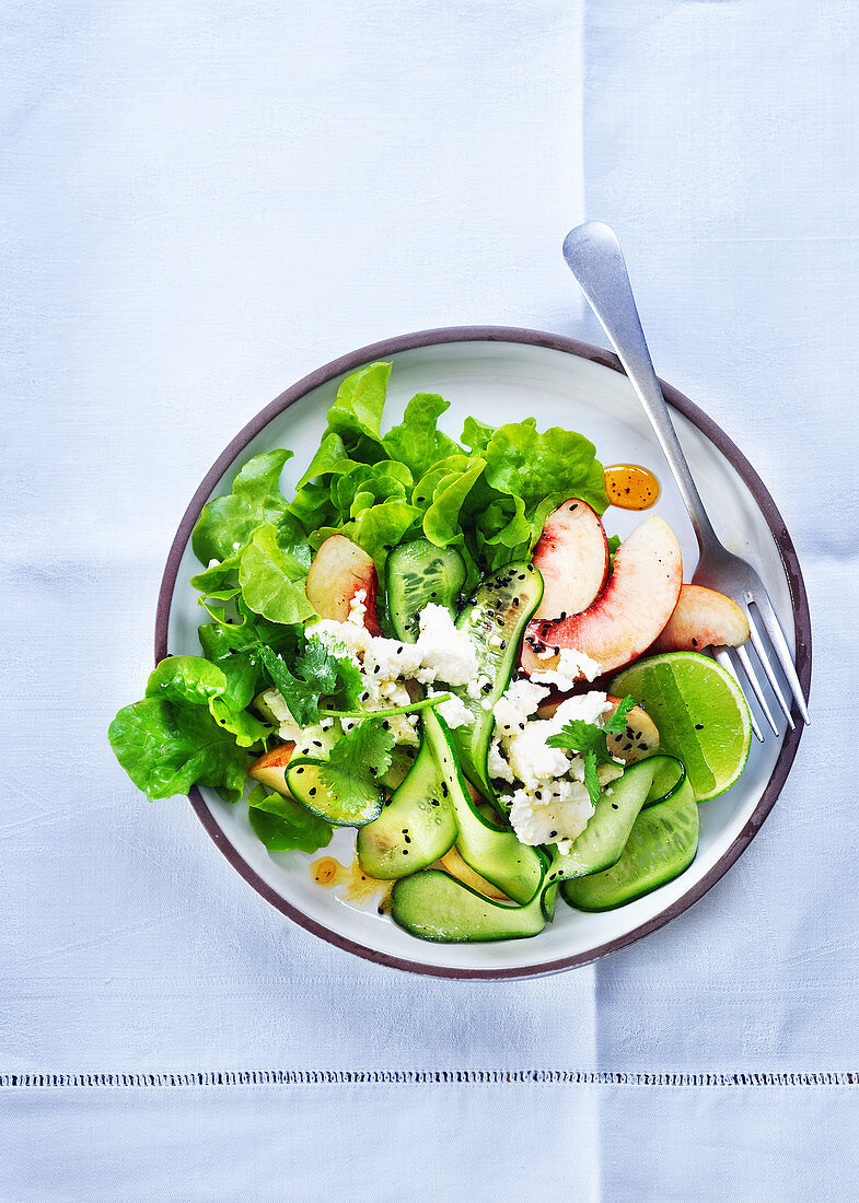 Salad with cucumber, peaches, feta and lime