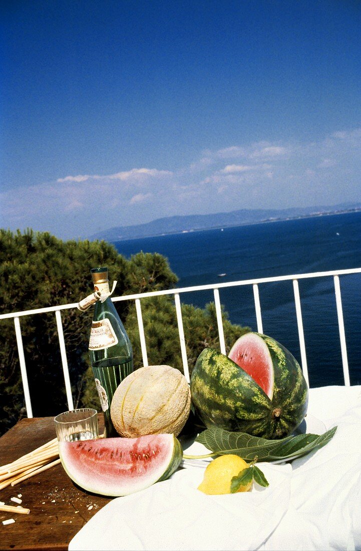 Melonen, Zitrone & Wein auf Balkon am Meer in Italien