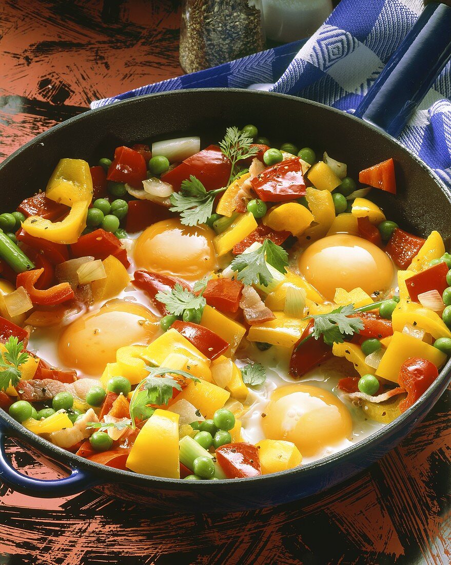 Pan-cooked vegetables with fried eggs in the pan