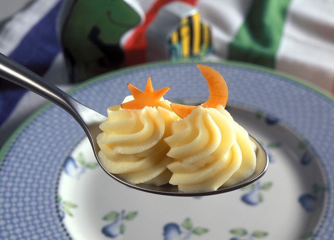 Two rosettes of creamy mashed potato on spoon