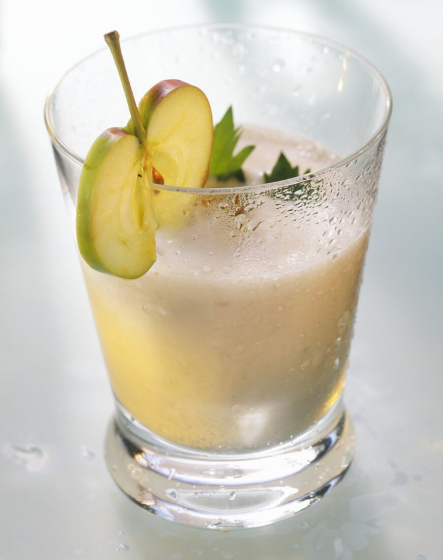 Apple & celery juice in glass, garnished with apple slice