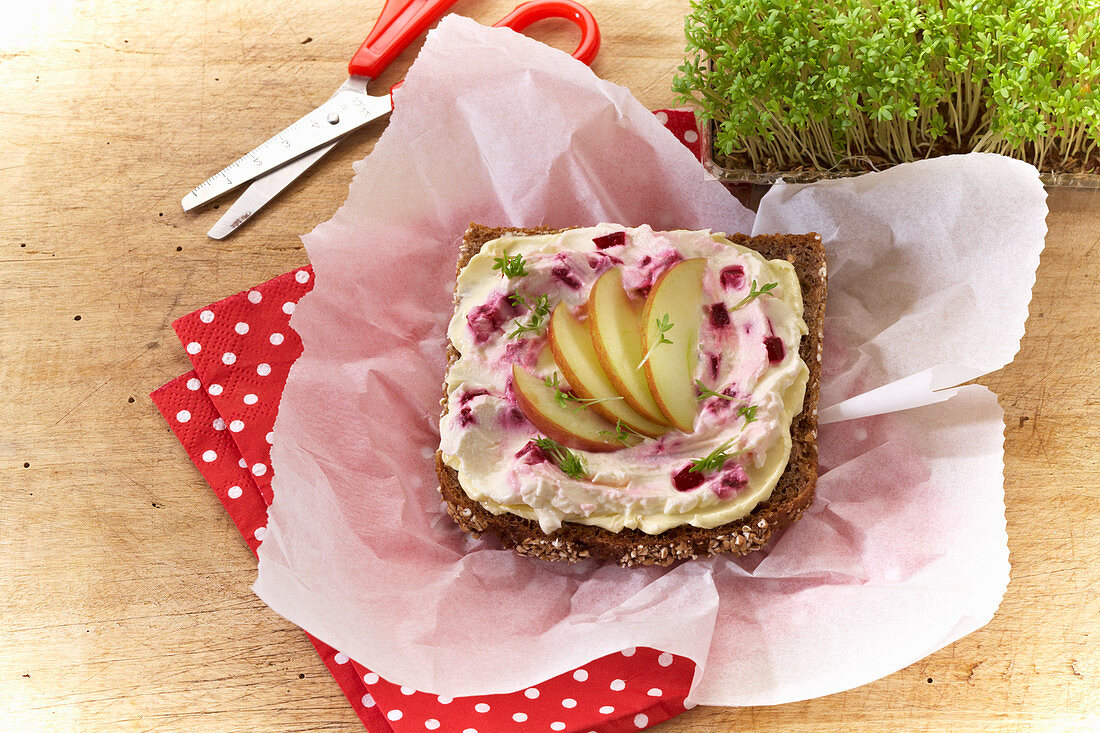 A slice of wholemeal bread topped with apple, beetroot and cress