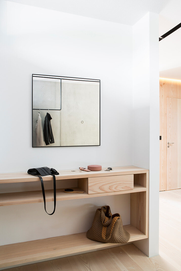 Sideboard aus hellem Holz und Spiegel im Eingangsbereich