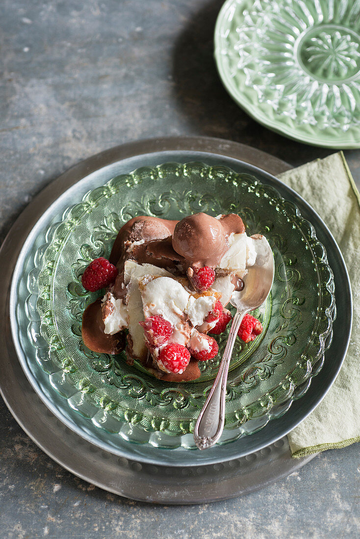 Eine Portion Schokoladeneis-Millefeuille mit Sahne und Himbeeren