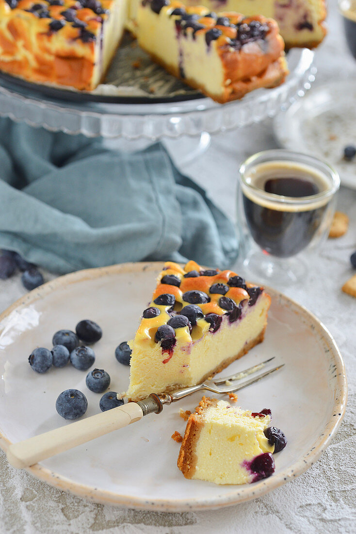 A piece of cheesecake with blueberries on a plate