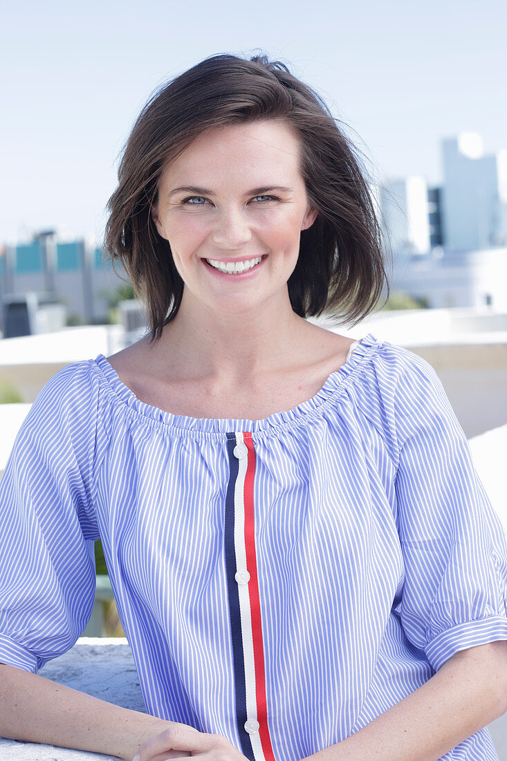 A young woman wearing a blue-and-white striped Carmen blouse