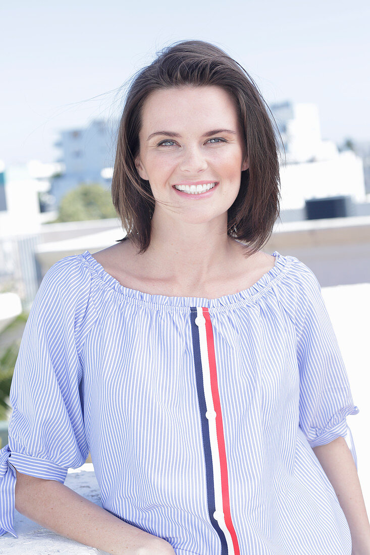 A young woman wearing a blue-and-white striped Carmen blouse