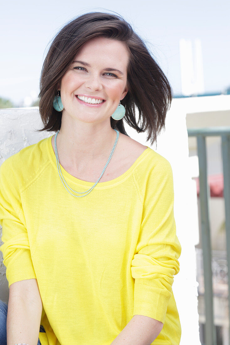 A young woman wearing a long-sleeved yellow top