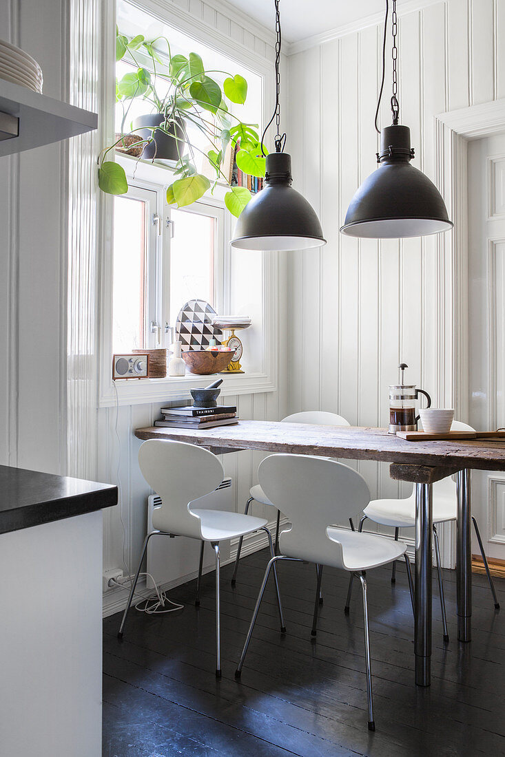 Designer chairs around wooden table in rustic kitchen-dining room