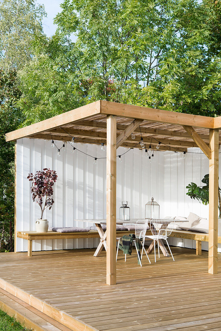 Sunny seating area on terrace with peregola and screen