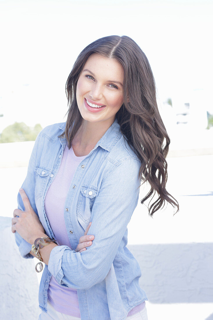 A young woman wearing a purple t-shirt and a denim shirt