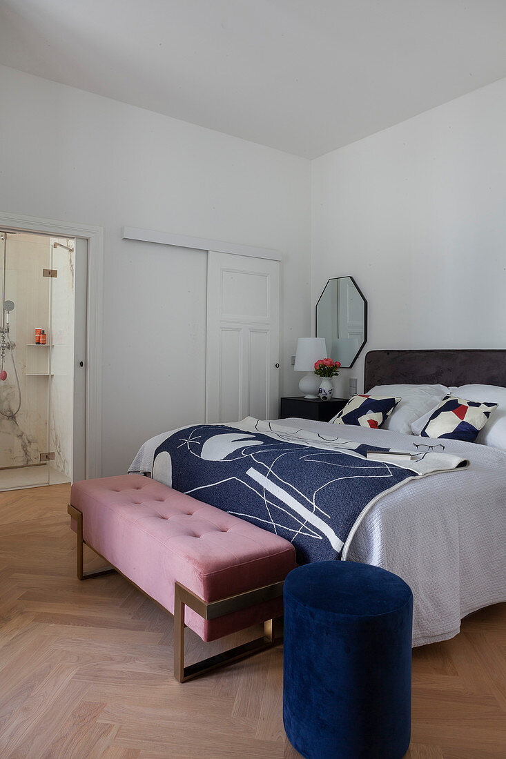 Blue pouffe and bedroom bench in bedroom with ensuite bathroom