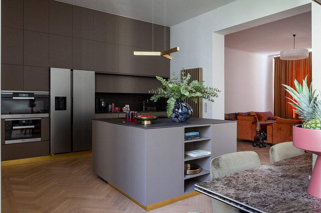 Island counter and dining table in elegant, open-plan kitchen decorated in grey