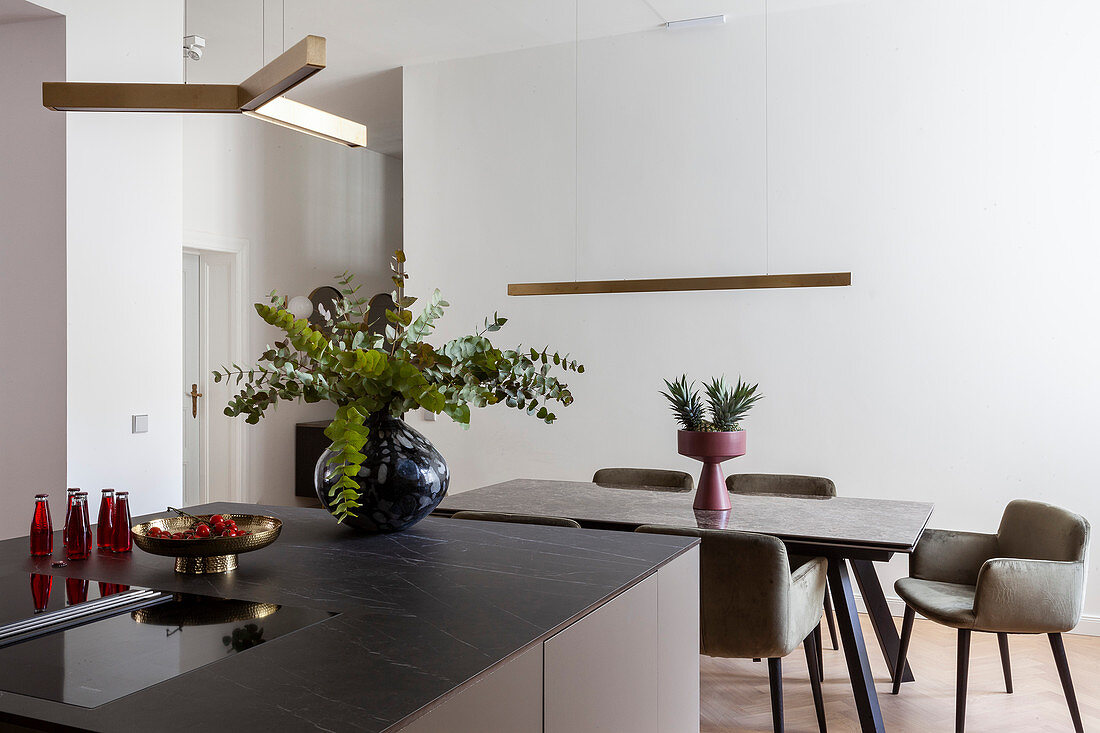 Upholstered chairs around modern dining table in puristic kitchen-dining room