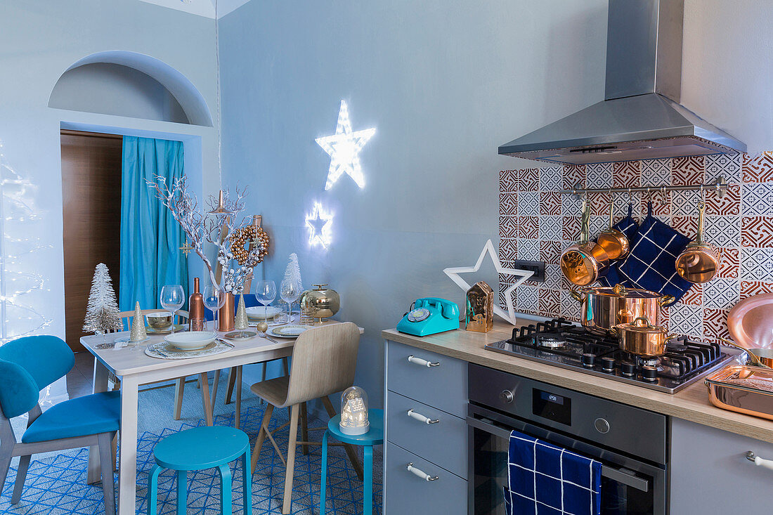 Christmas decorations on cooker and dining table in blue kitchen
