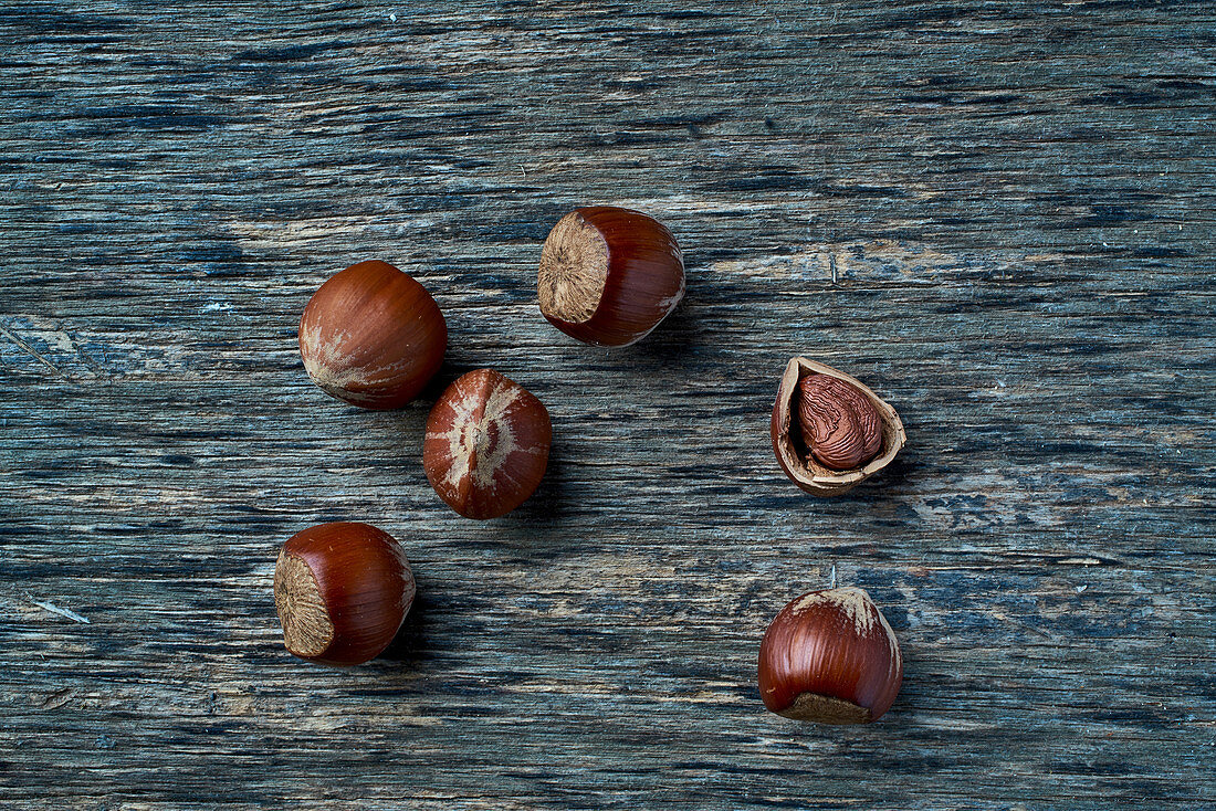 Hazelnuts, whole and shelled, on a wooden surface