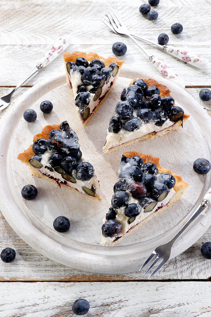 Vier Stücke Frischkäsetarte mit Blaubeeren