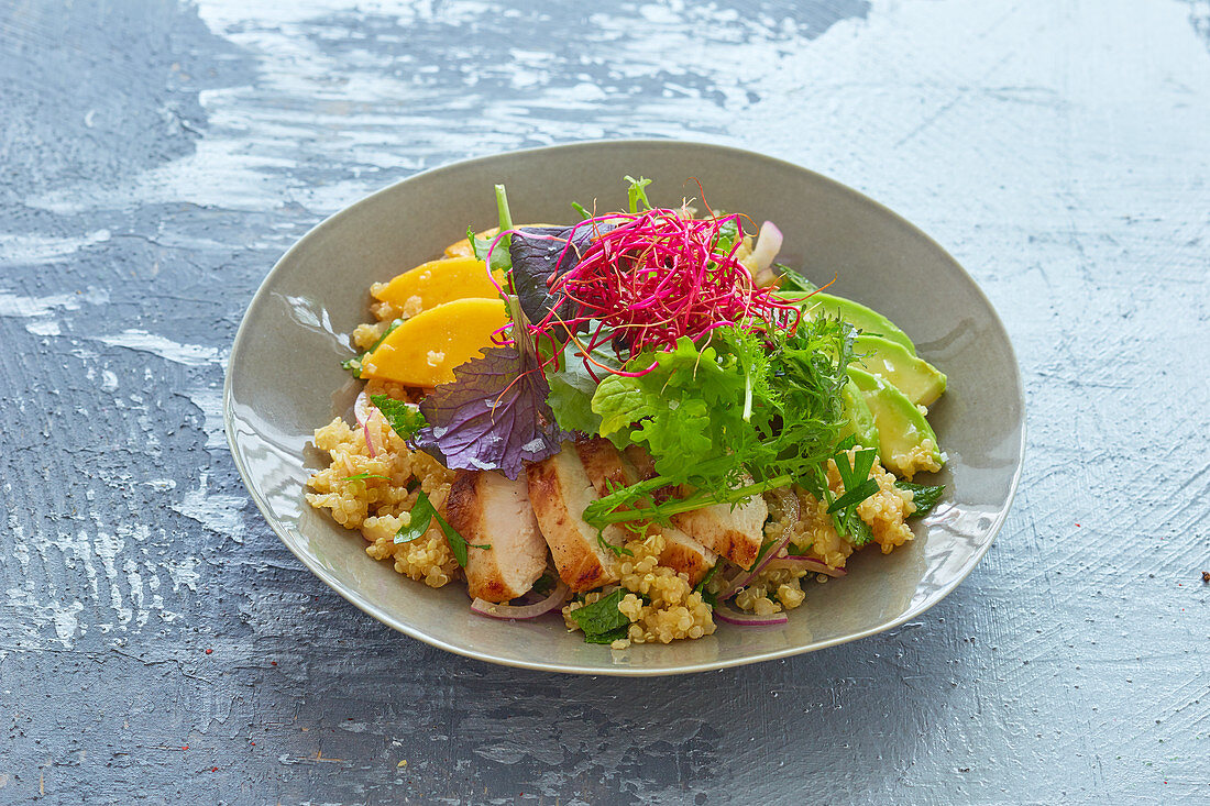 Colorful wild herb salad with couscous and chicken breast