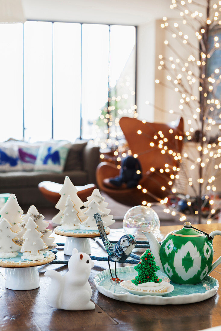 Teekanne auf Porzellanplatte daneben weihnachtliches Gebäck