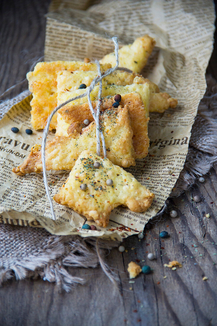 Cheese pastries with peppercorns on newspaper