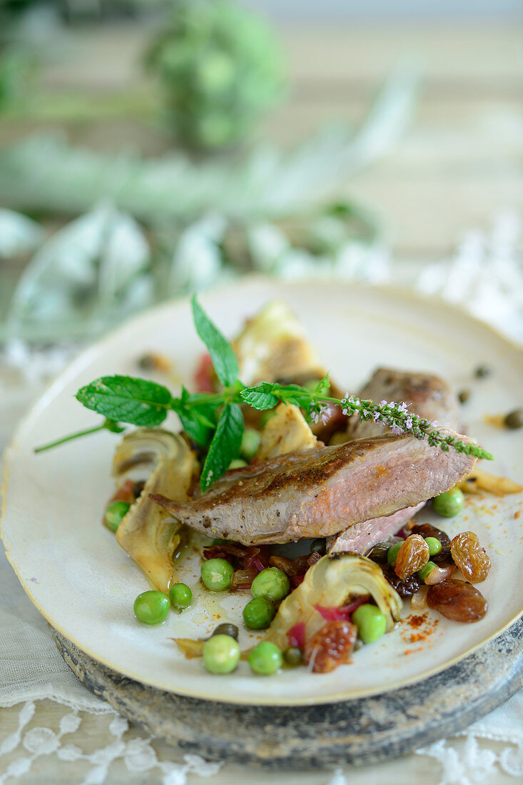 Pink roasted lamb fillet with artichoke and pea ragout (Turkey)