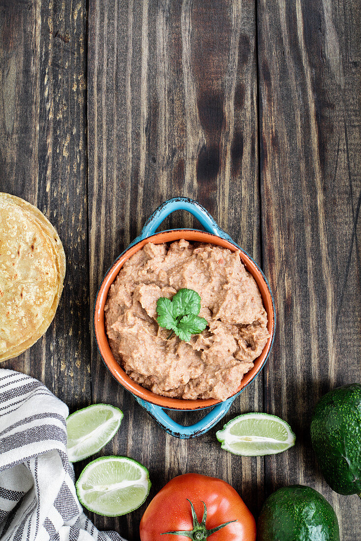 Refried beans with fried corn tortillas, avocados, tomatoes and fresh limes