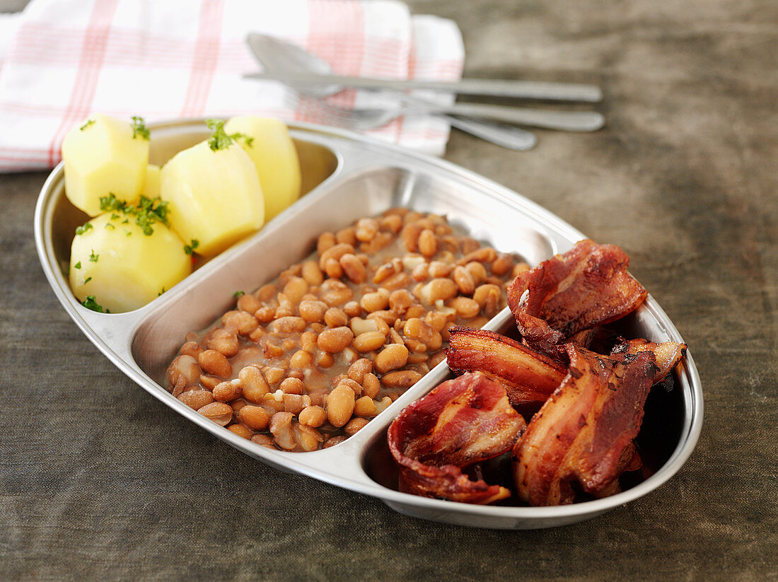 Brown beans with fried bacon and boiled potatoes