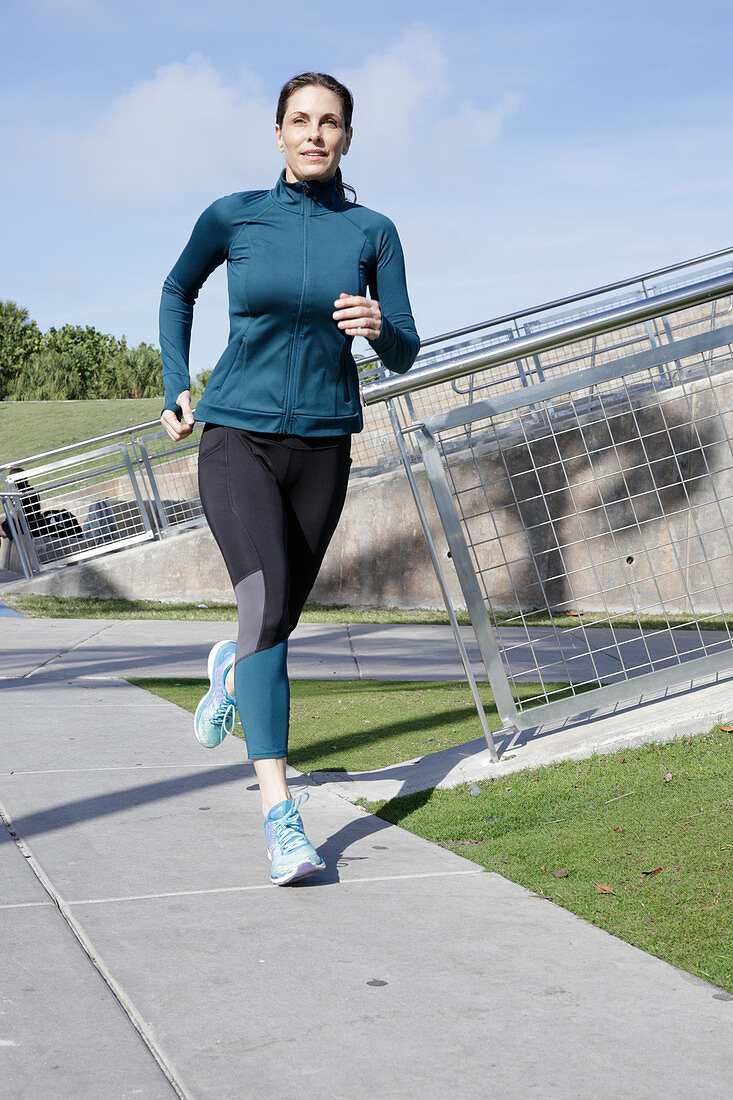 A brunette woman jogging