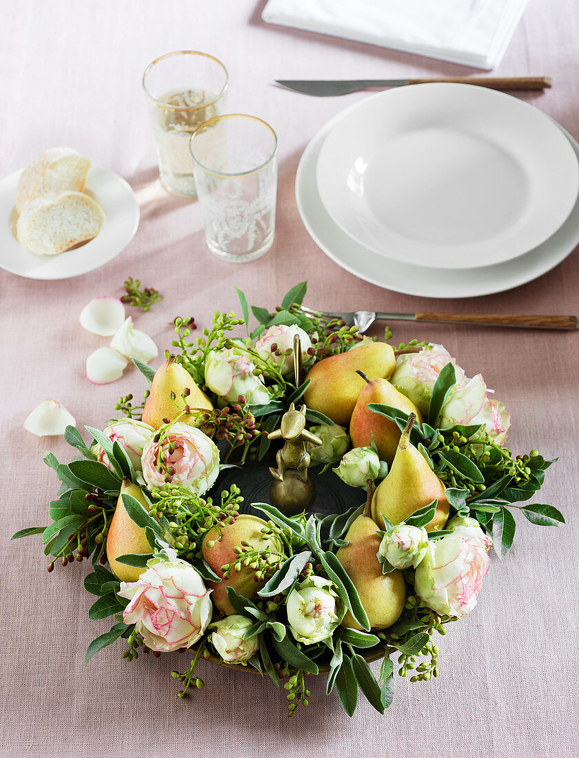 Herbstlicher Kranz mit Birnen und Rosen als Tischdekoration