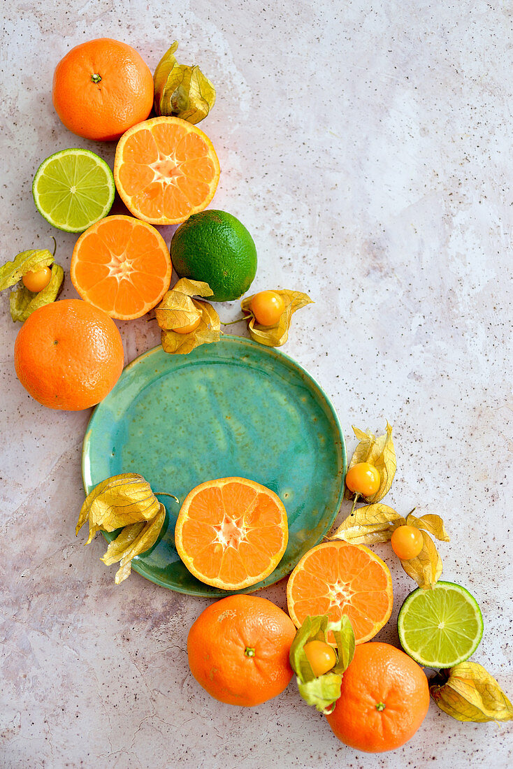 Citruses and physalis arranged on a light background