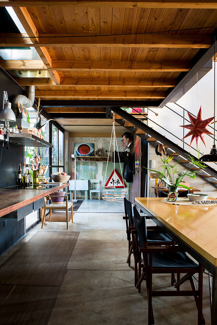 Küche und Esstisch im Loft, im Hintergrund Treppe