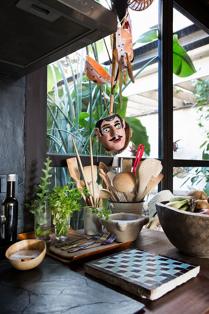 Kitchen utensils and mask in front of window