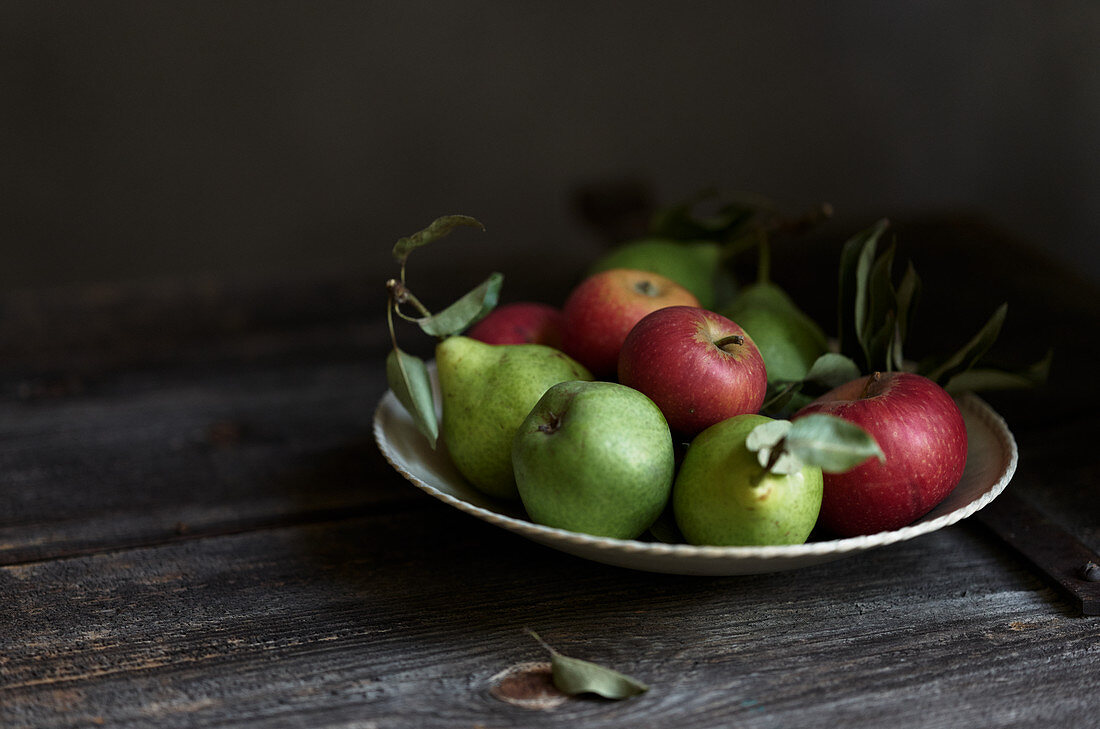 Apples and pears on a rustic wooden table