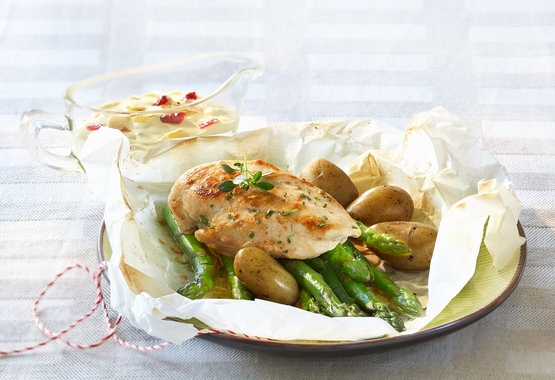 Asparagus with chicken breast and potatoes in parchment paper