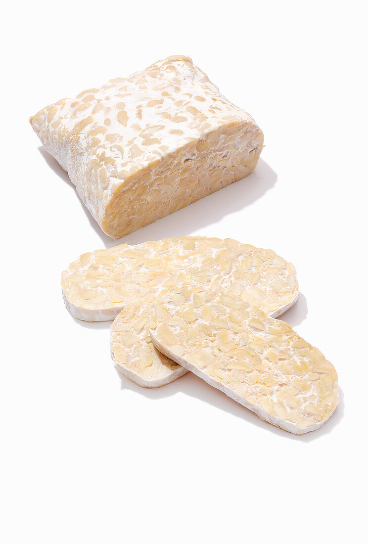 A piece of tempeh, partially sliced