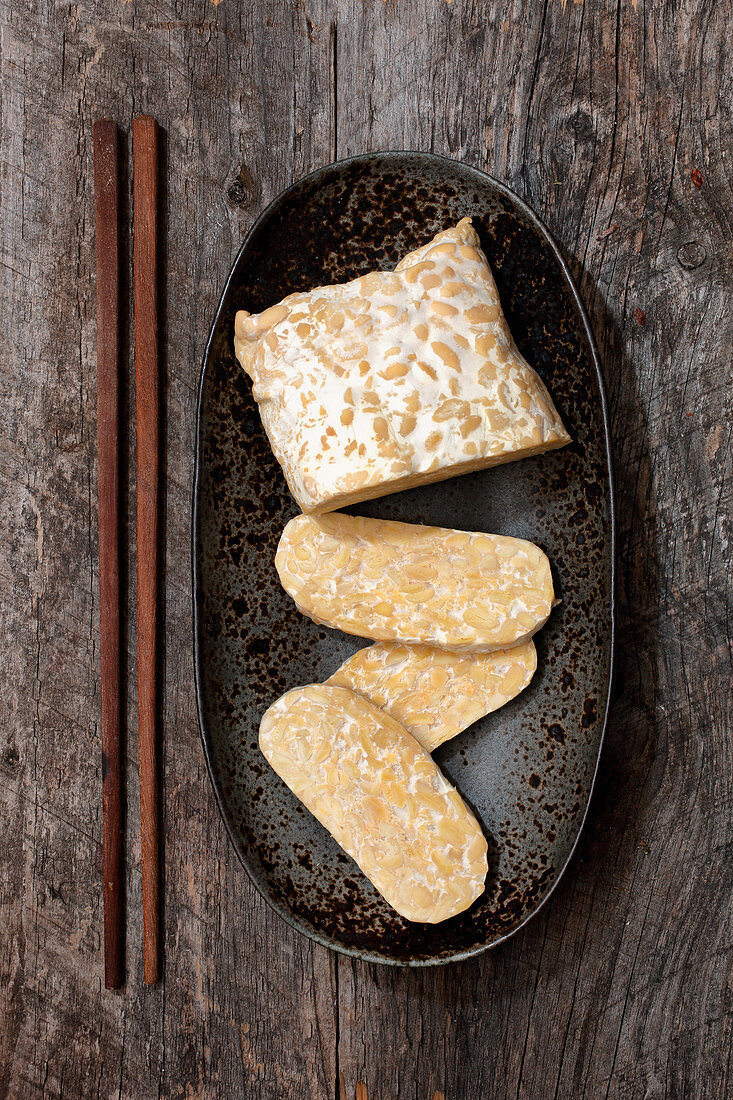 A piece of tempeh, partially sliced