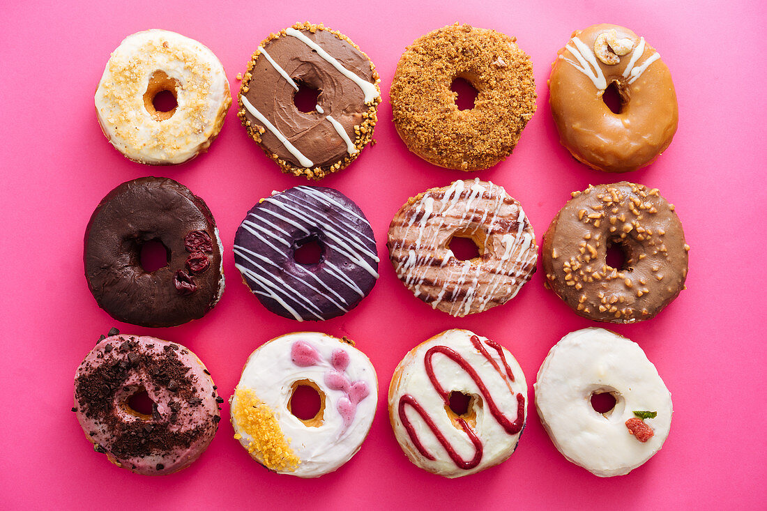 Verschiedene Donuts auf rosa Hintergrund