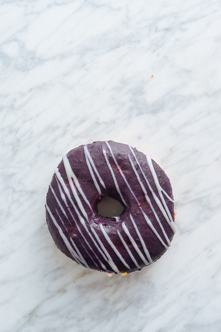 Donut mit Schokoladenglasur auf Marmorhintergrund