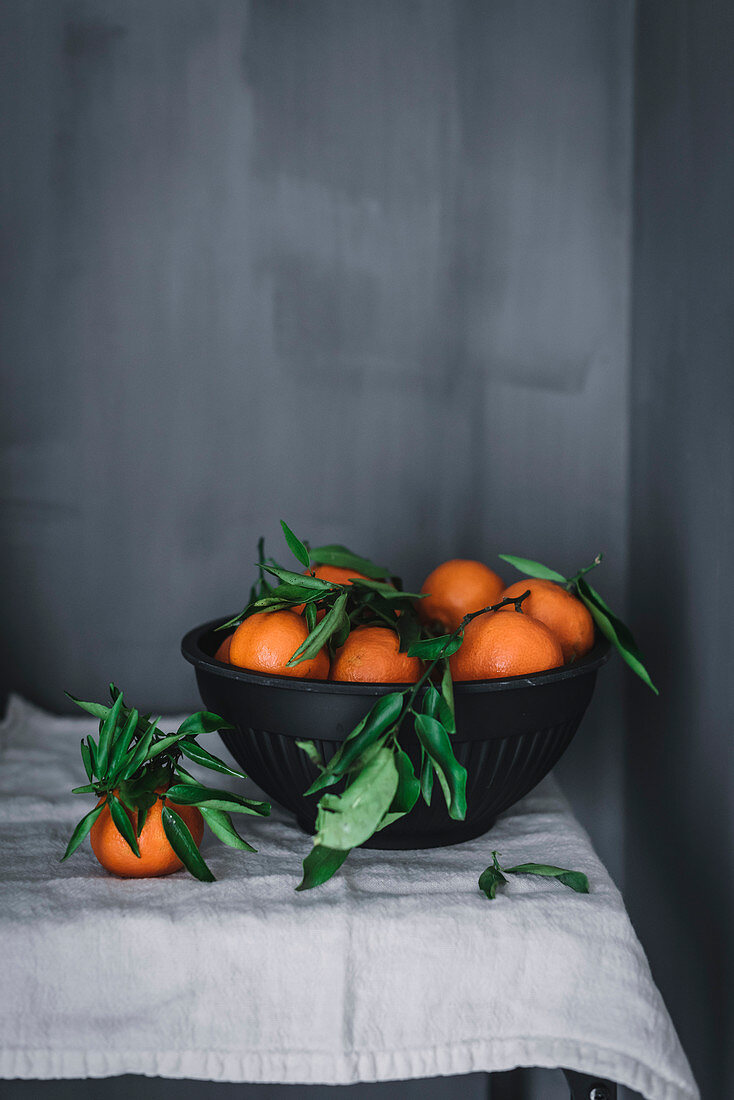 Orange tangerines in ceramic ornamental bowl on table