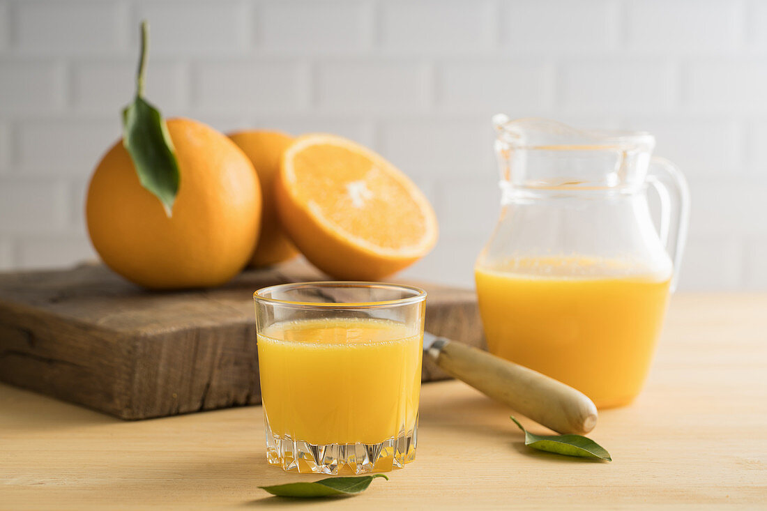 Orangensaft im Glas und in einer Glaskaraffe