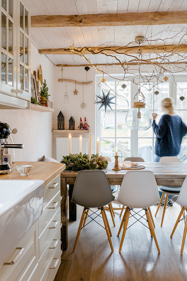 Woman at window in dining room decorated for Christmas